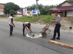 Personil Polsek Pelawan Singkut Tutup Jalan Berlubang
